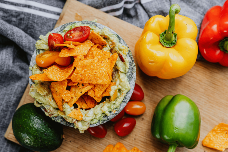 A close-up of crunchy, golden Popcorn Chips seasoned with spices, served in a bowl with a side of creamy dip, perfect for snacking.